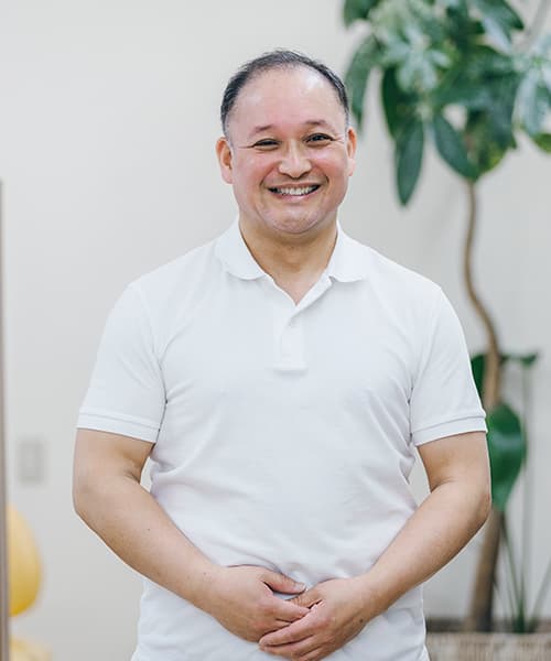 笑顔で立つ、だて歯科クリニック院長の伊達浩
